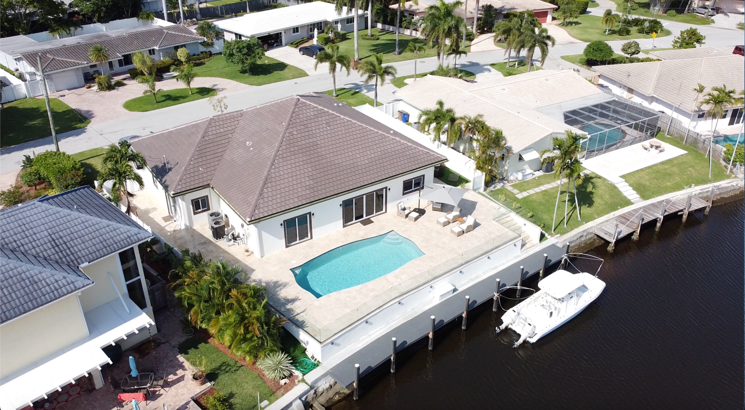 Aerial view of waterfront canal home with pool and private dock